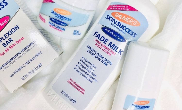 Palmer's Skin Success Fade Milk and Fade Cream, top skincare products recommended by dermatologists, on a white blanket